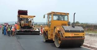 Paver and vibratory roller working in line
