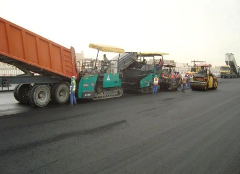 Dump truck feeding the paver, roller behind